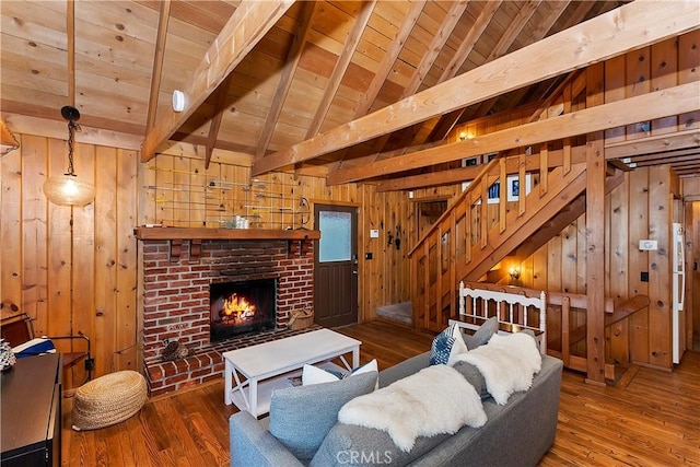 living room featuring hardwood / wood-style floors, wood walls, a fireplace, and wooden ceiling