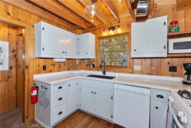 kitchen featuring white appliances, wooden ceiling, sink, wooden walls, and white cabinetry