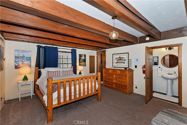 bedroom featuring sink, beamed ceiling, and dark colored carpet