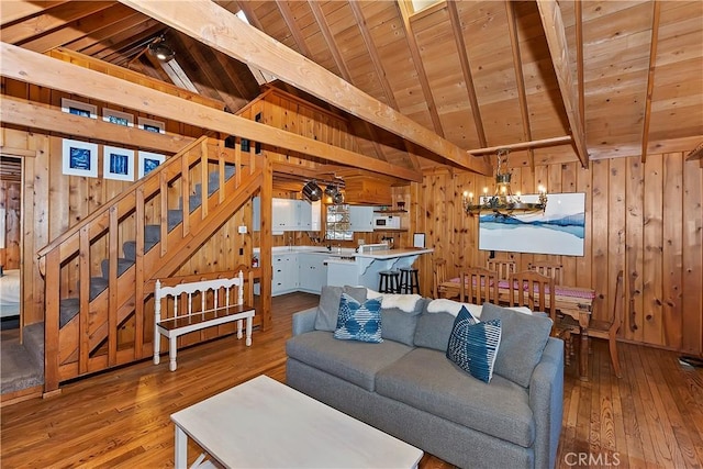 living room with lofted ceiling with beams, wooden ceiling, wood walls, and hardwood / wood-style flooring