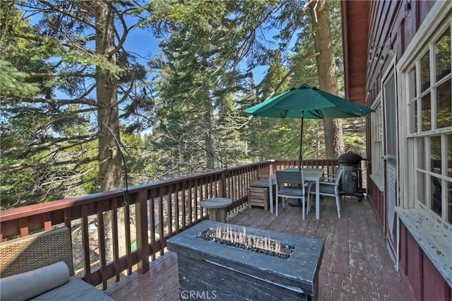 wooden deck with grilling area and an outdoor fire pit