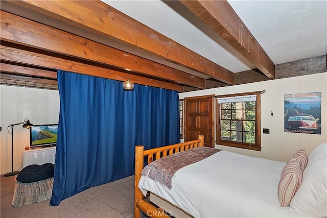 carpeted bedroom featuring beamed ceiling