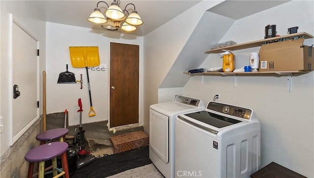 washroom featuring washing machine and dryer and an inviting chandelier