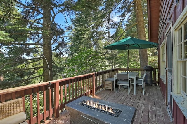 deck with area for grilling and an outdoor fire pit