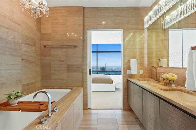 900 W Olympic Blvd Unit 42A, Los Angeles, CA 90015 - ensuite bathroom with double vanity, a garden tub, tile patterned flooring, a chandelier, and tile walls
