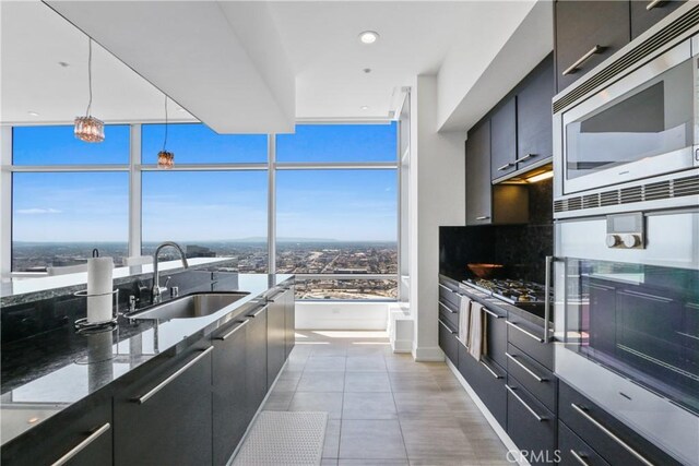 900 W Olympic Blvd Unit 42A, Los Angeles, CA 90015 - kitchen featuring stainless steel microwave, dark cabinets, modern cabinets, dark stone counters, and recessed lighting