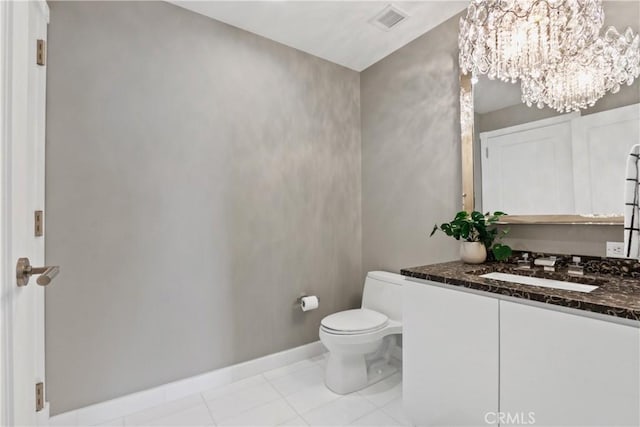 bathroom featuring tile patterned flooring, vanity, a chandelier, and toilet