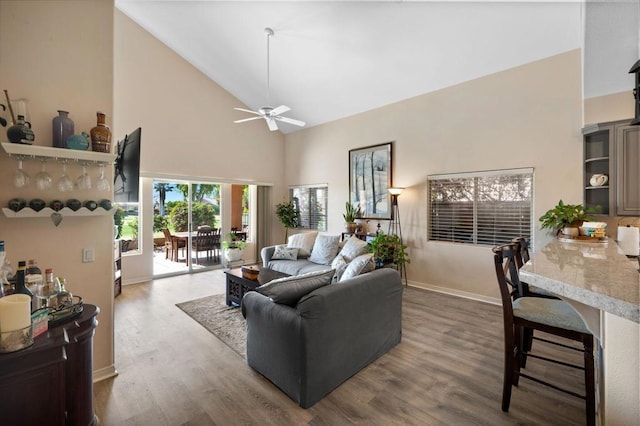 living room featuring hardwood / wood-style flooring, high vaulted ceiling, and ceiling fan