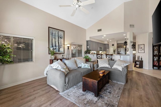 living room featuring hardwood / wood-style floors, ceiling fan, plenty of natural light, and high vaulted ceiling