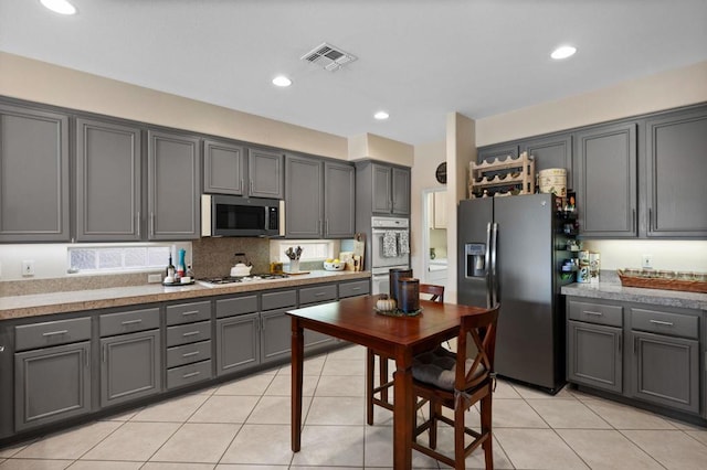 kitchen featuring appliances with stainless steel finishes, gray cabinetry, and light tile patterned flooring