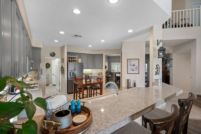 kitchen featuring sink, stainless steel appliances, kitchen peninsula, gray cabinets, and light tile patterned floors