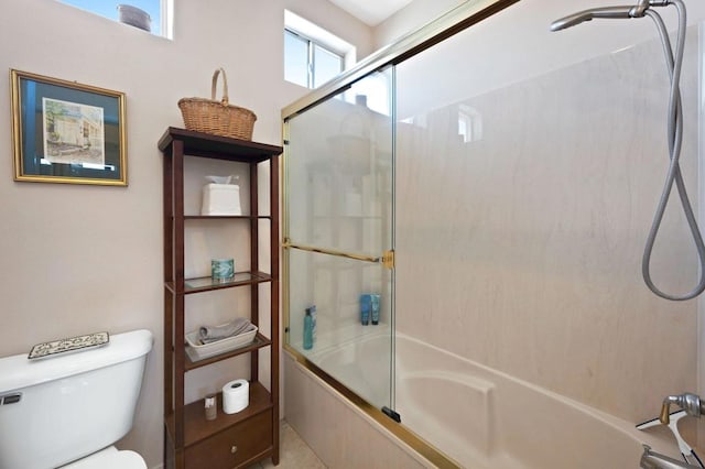 bathroom featuring enclosed tub / shower combo and toilet