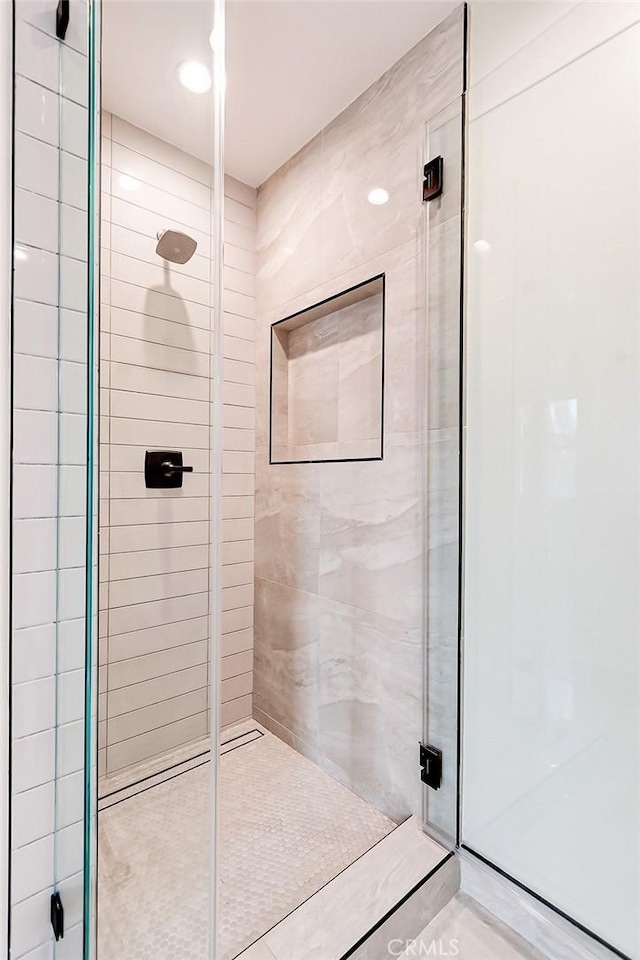 bathroom with a shower with door