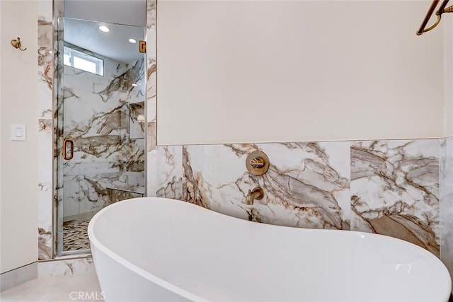 bathroom with separate shower and tub and tile walls