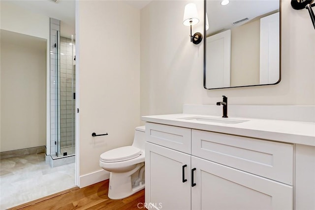 bathroom featuring hardwood / wood-style floors, vanity, toilet, and a shower with shower door