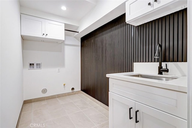 clothes washing area featuring washer hookup, gas dryer hookup, light tile patterned floors, and sink