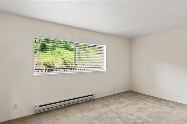 carpeted spare room with a baseboard heating unit and a healthy amount of sunlight