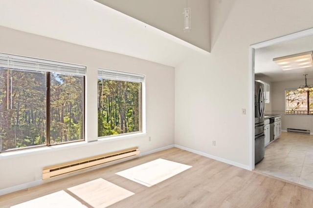 interior space with a baseboard heating unit, a notable chandelier, and a wealth of natural light