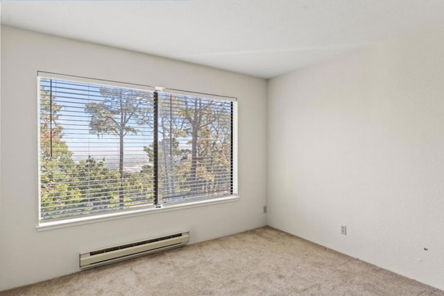 unfurnished room featuring baseboard heating and light colored carpet