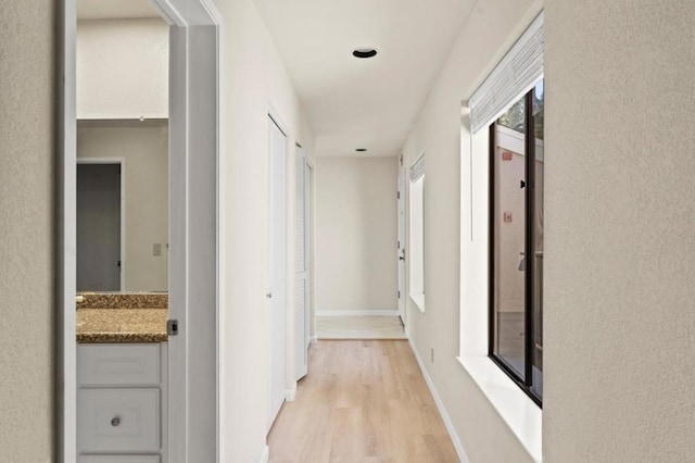 corridor with light hardwood / wood-style flooring