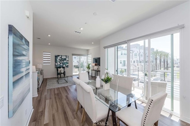 dining space with wood-type flooring