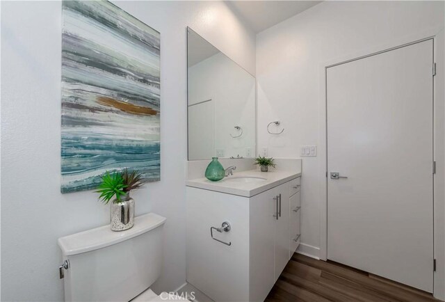 bathroom featuring hardwood / wood-style flooring, toilet, and vanity