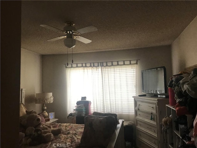 bedroom with ceiling fan and a textured ceiling