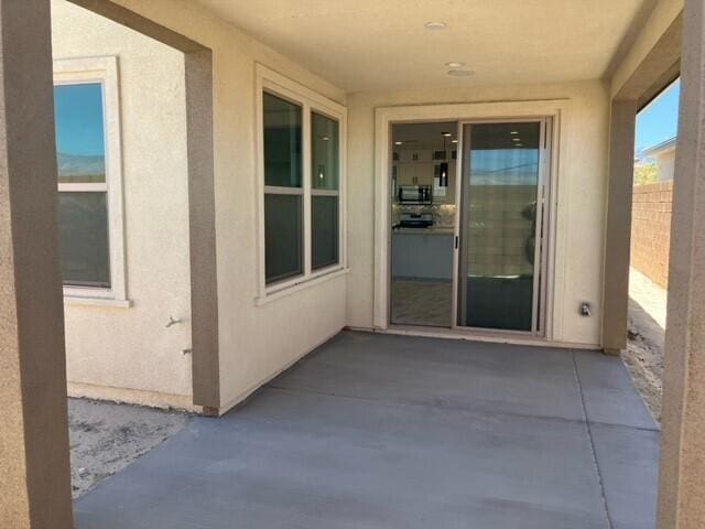 view of exterior entry with a patio area