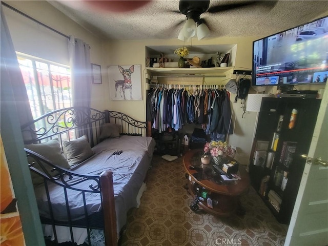 bedroom with a textured ceiling, a closet, and ceiling fan