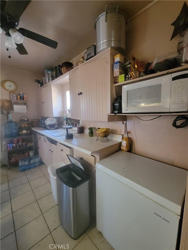 kitchen featuring light tile patterned flooring, fridge, sink, and ceiling fan