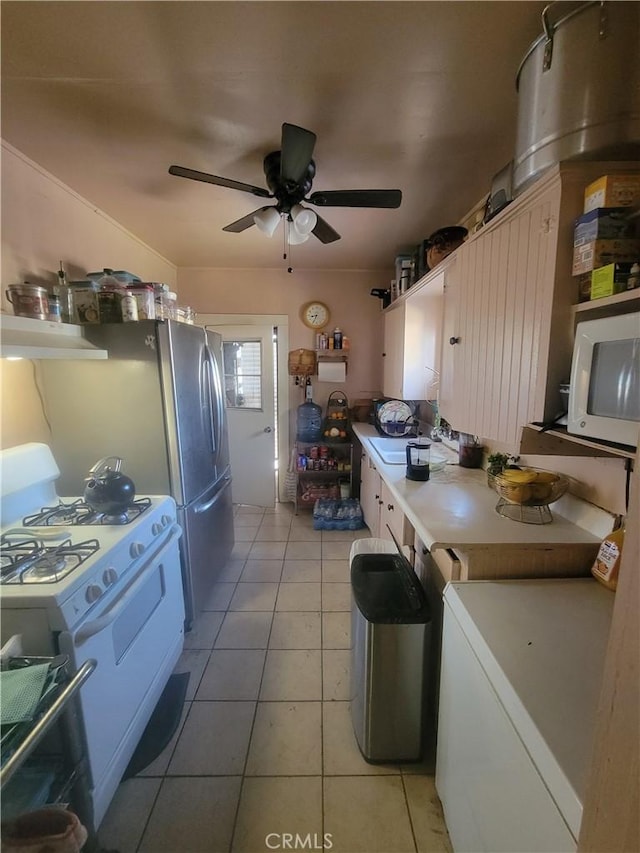 kitchen with light tile patterned flooring, sink, ceiling fan, and white appliances