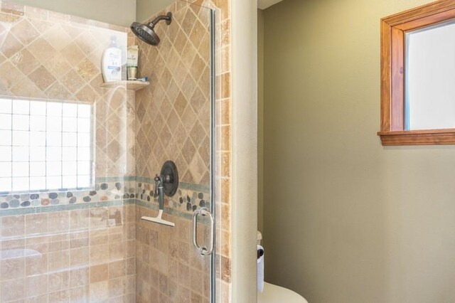 bathroom featuring an enclosed shower and toilet