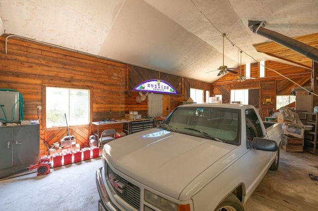 garage featuring ceiling fan and wood walls