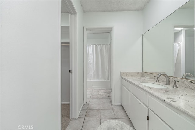 bathroom with tile flooring, vanity, and a textured ceiling