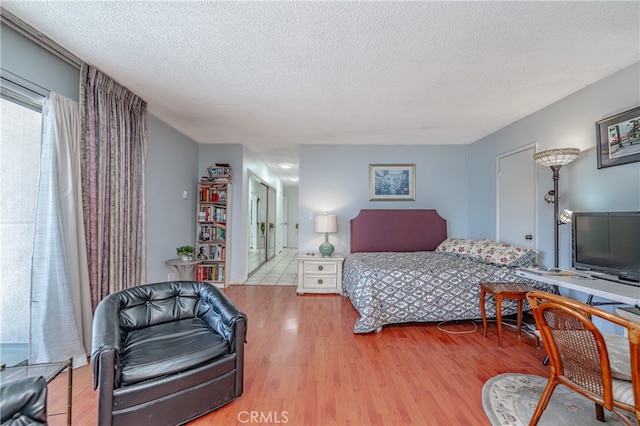 bedroom with wood-type flooring and a textured ceiling