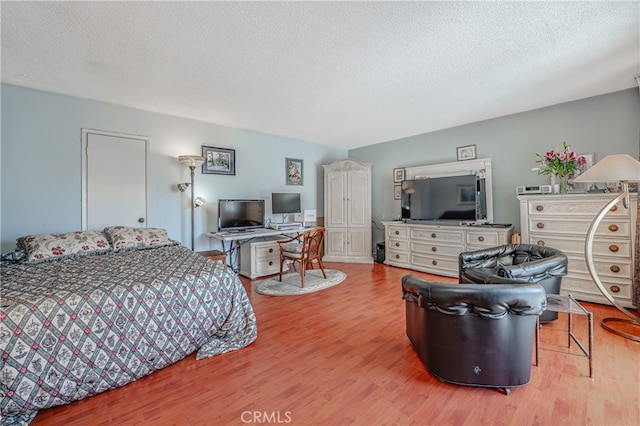 bedroom with light wood-type flooring and a textured ceiling