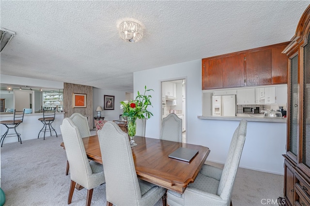 carpeted dining area featuring a textured ceiling