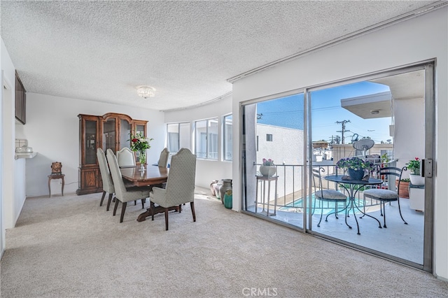 dining space featuring a textured ceiling and carpet