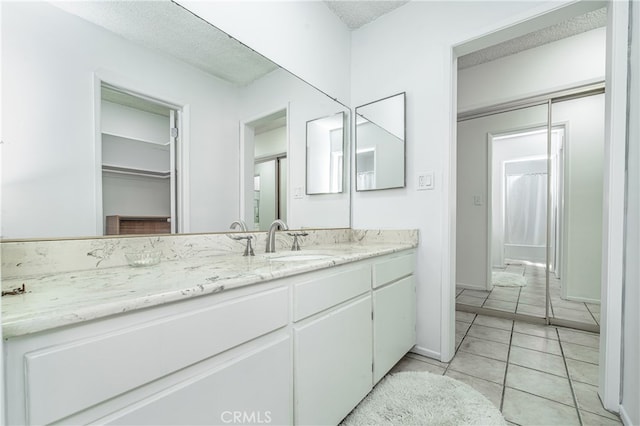 bathroom featuring tile floors and vanity with extensive cabinet space