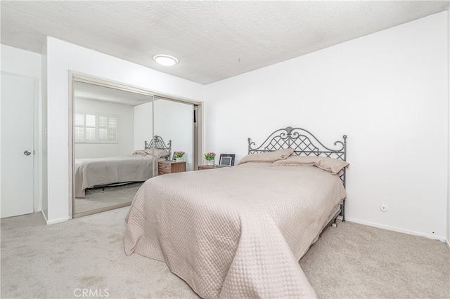 bedroom with carpet flooring, a closet, and a textured ceiling