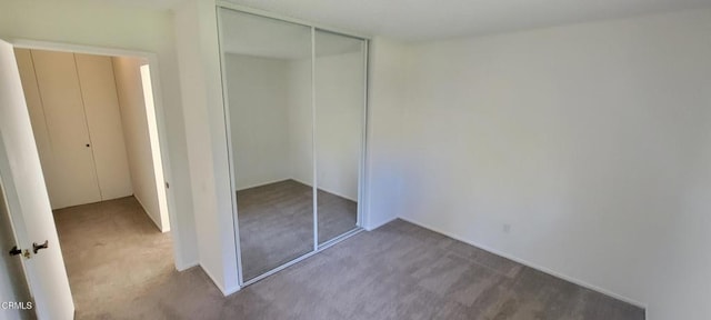 unfurnished bedroom featuring carpet floors and a closet