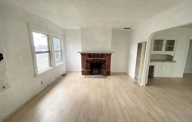 unfurnished living room with light wood-type flooring and a fireplace