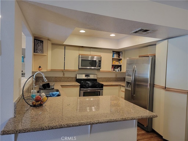 kitchen with kitchen peninsula, sink, stainless steel appliances, and dark hardwood / wood-style floors