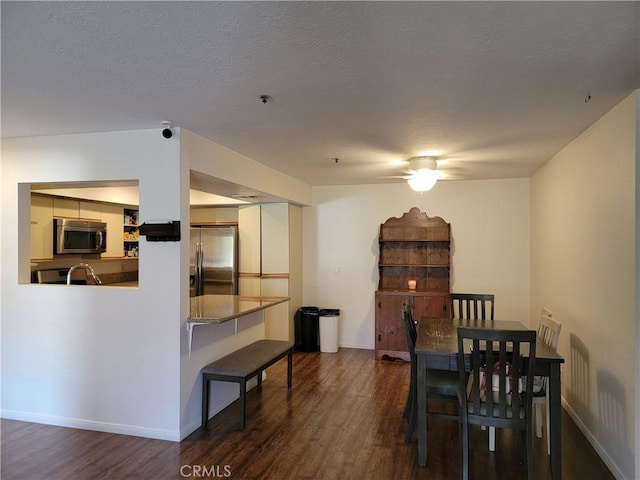 dining area featuring a textured ceiling, dark hardwood / wood-style floors, and sink