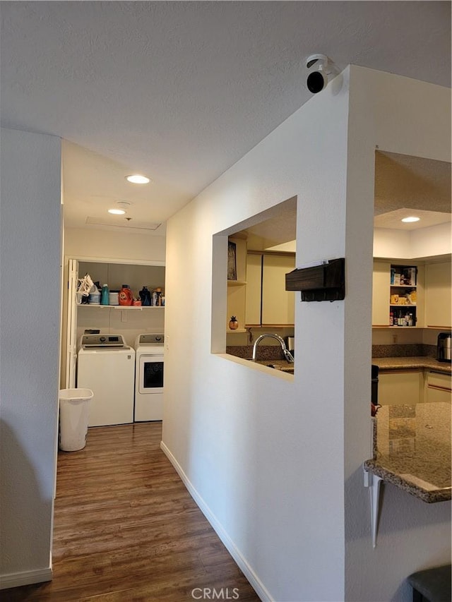 corridor featuring built in shelves, sink, separate washer and dryer, dark hardwood / wood-style floors, and a textured ceiling