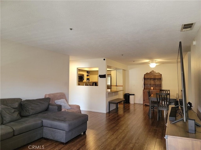 living room with dark wood-type flooring and a textured ceiling