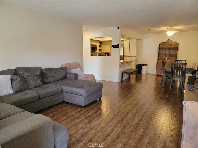 living room with a textured ceiling and dark wood-type flooring