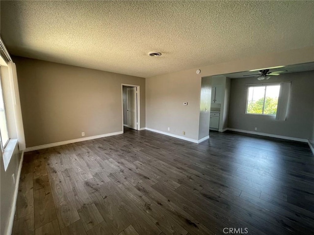 spare room featuring a textured ceiling and dark hardwood / wood-style floors