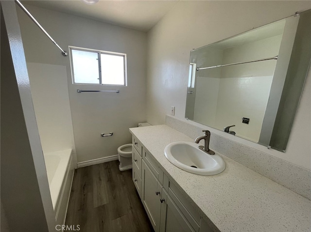 full bathroom featuring hardwood / wood-style floors, toilet, vanity, and shower / washtub combination