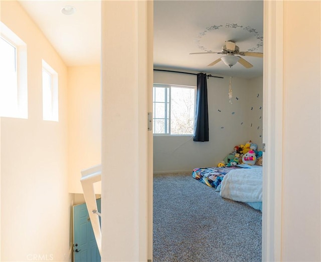 bedroom with ceiling fan, multiple windows, and carpet flooring